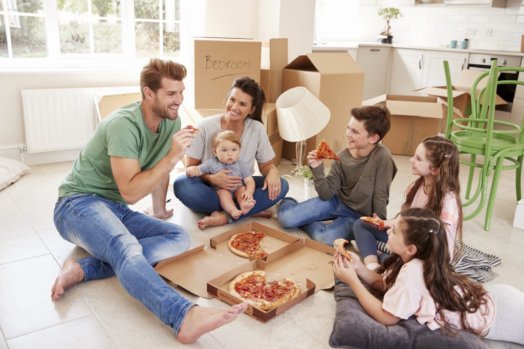 family on pizza break from unpacking boxes